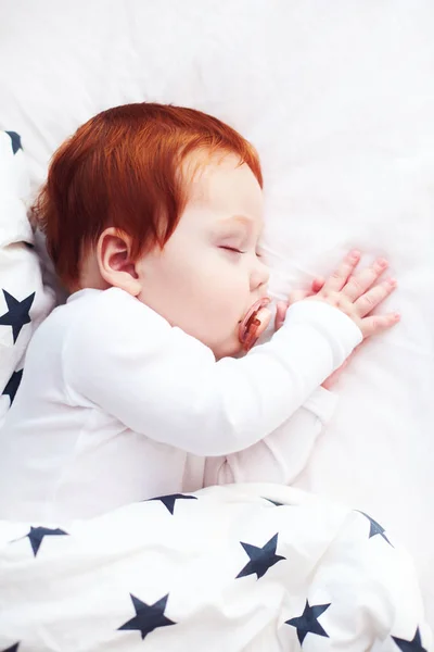 Top view of redhead infant baby sleeping peacefully in bed — стоковое фото