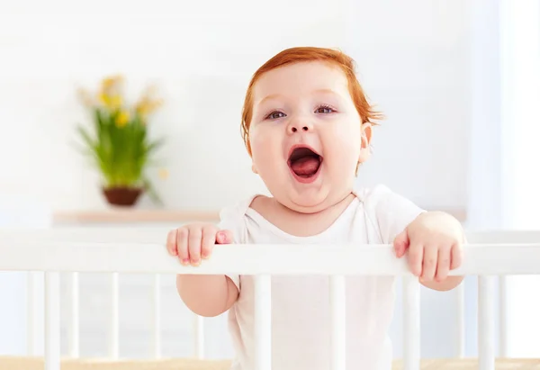 Poprtait de lindo bebé de pie en una cuna en casa — Foto de Stock