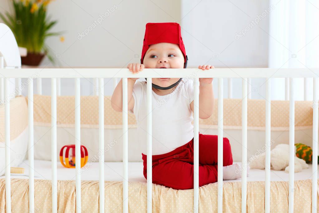 funny baby bites his cot as teeth are pricked