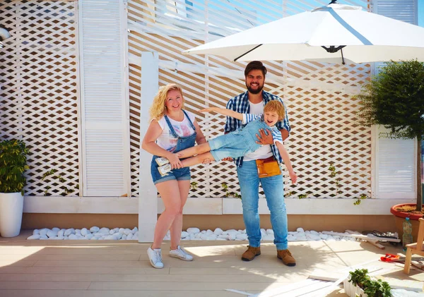 Familia feliz establecer un enrejado para las plantas en el patio —  Fotos de Stock