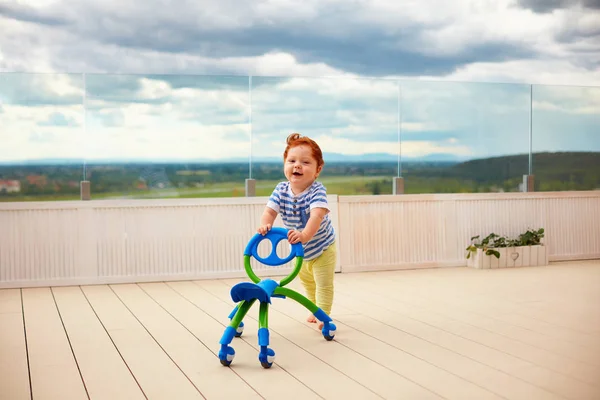 Szczęśliwy toddler chłopca pchanie, spychając do koszyka, na zewnątrz — Zdjęcie stockowe