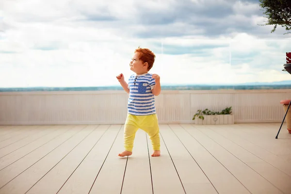 Ritratto di rossa carina, un bambino di un anno che cammina sul ponte — Foto Stock