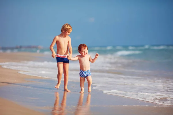 Dois irmãos, crianças bonitos se divertindo na praia de areia — Fotografia de Stock