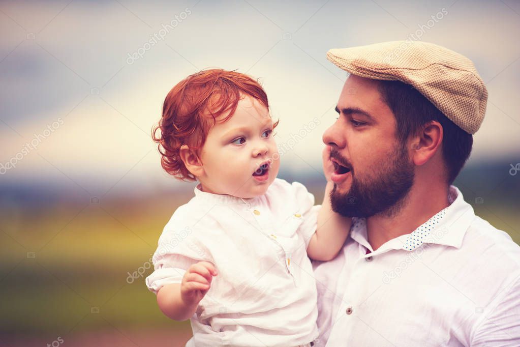 portrait of father and cute redhead son in the countryside