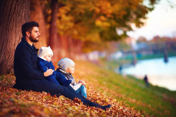 Porträt eines Vaters mit Kindern, die den Herbst zwischen fallendem Laub genießen — Stockfoto