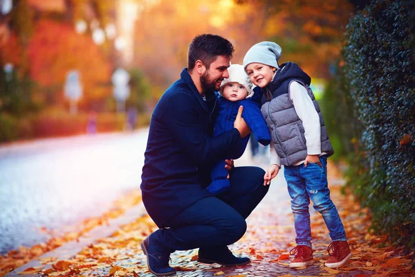 Retrato de pai feliz com filhos no passeio ao longo da rua de outono — Fotografia de Stock