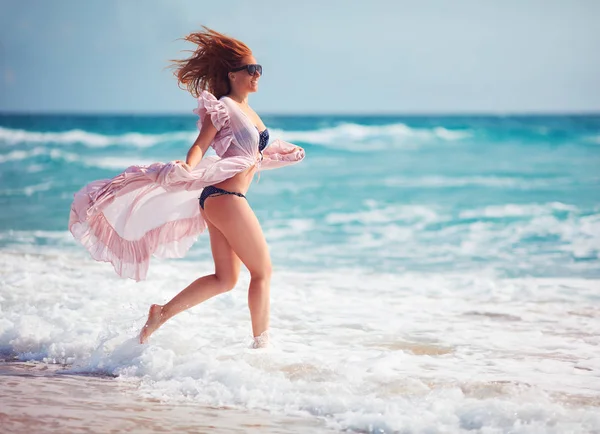 美丽、 年轻的女人在波浪中运行着暑假的到来 — 图库照片