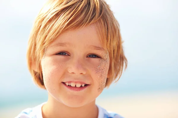 Jóképű fiú arcát, szeplők és a homok, a napos nyári portréja — Stock Fotó