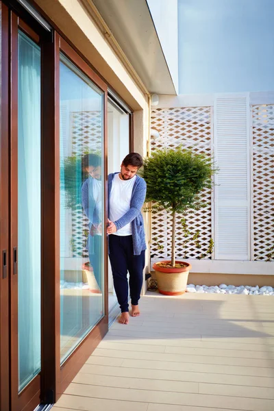 Homme ouvrant des portes coulissantes en verre sur le patio à la maison — Photo