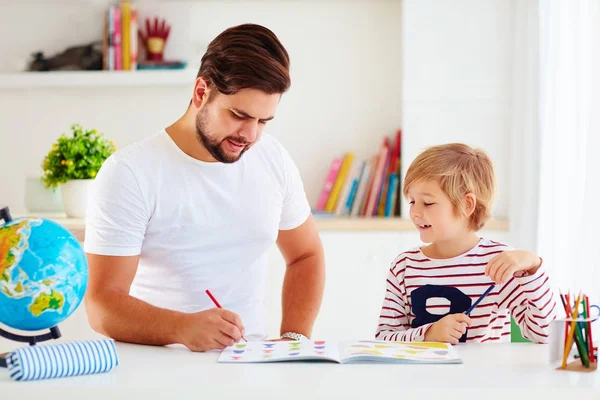 Padre e hijo se divierten juntos en el escritorio, colorear el libro — Foto de Stock