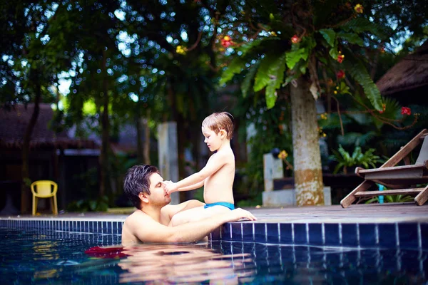 Padre e hijo disfrutan relajarse en la piscina en una escapada tranquila — Foto de Stock