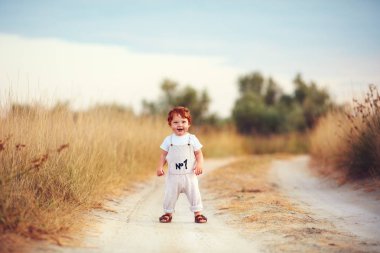 sevimli bebek bebek çocuk having fun yaz Field'da yolda oynayan