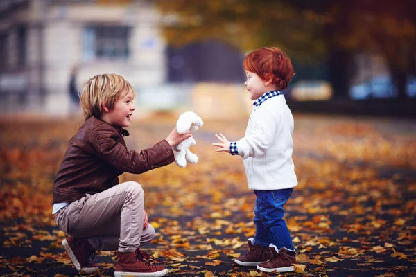 Aranyos divatos testvérek, gyerekek, fiúk játszik együtt, őszi park — Stock Fotó