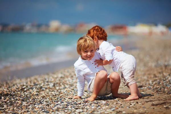 Funny candid moment of kid catching his little baby brother, when he's falling, family summer vacation — Stock Photo, Image