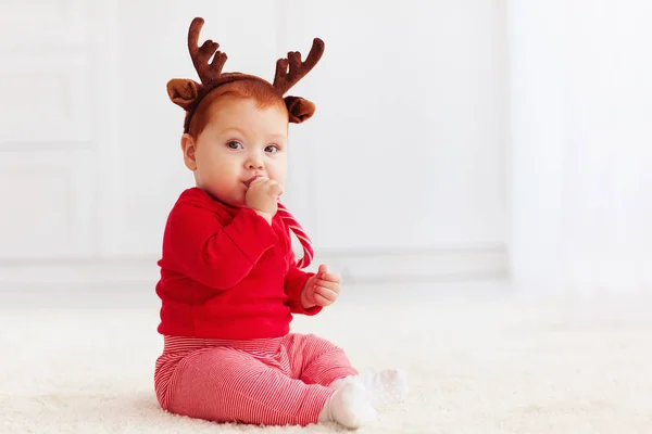 Cute little redhead baby boy with reindeer band tasting christma — Stock Photo, Image