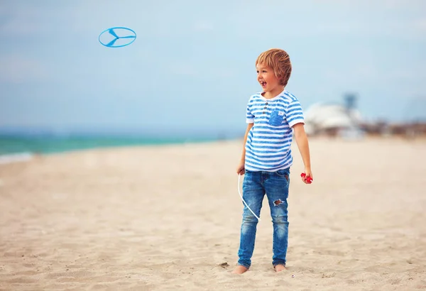 Delighter lindo niño, niño que se divierte en la playa, jugando con el juguete de la hélice —  Fotos de Stock