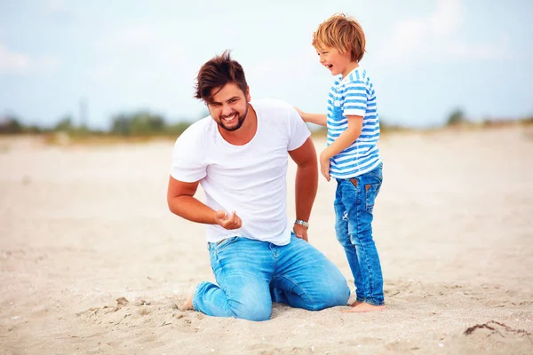 Padre e hijo alegres, diversión familiar, jugar en la playa de verano —  Fotos de Stock