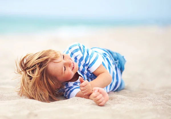 Lindo niño feliz riendo, niño divirtiéndose en la playa de arena, vacaciones de verano —  Fotos de Stock