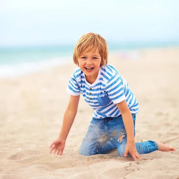 Feliz, garoto encantado, menino se divertindo, brincando na areia na praia — Fotografia de Stock