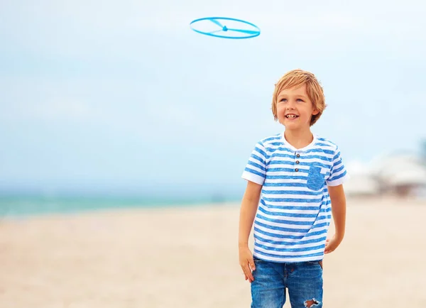 Blij schattige jonge jongen, kind plezier op zandstrand, recreatieve activiteit spelen met speelgoed van de propeller — Stockfoto