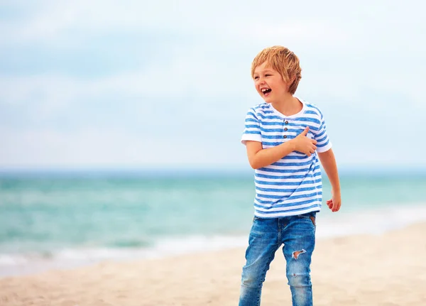 Lindo niño feliz riendo, niño divirtiéndose en la playa de arena, vacaciones de verano —  Fotos de Stock