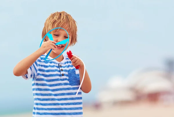 Deliziato carino ragazzo, bambino che si diverte sulla spiaggia sabbiosa, giochi di attività ricreative con il giocattolo dell'elica — Foto Stock