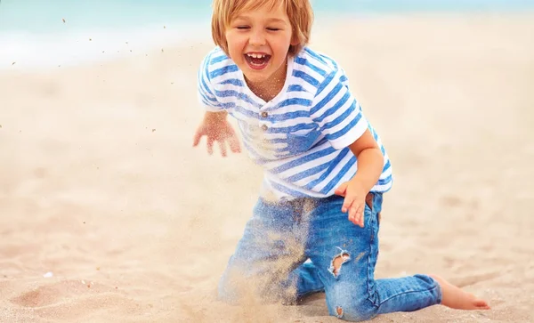Feliz, niño encantado, chico divirtiéndose, jugando en la arena en el be —  Fotos de Stock