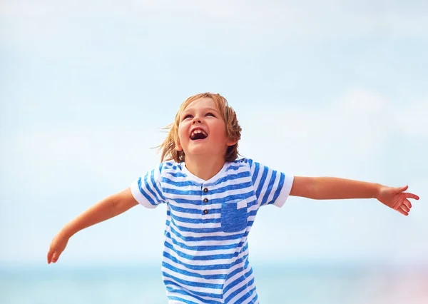 Roztomilý emocionální kluk, kluk zářit štěstím, běh přes písečnou pláž — Stock fotografie