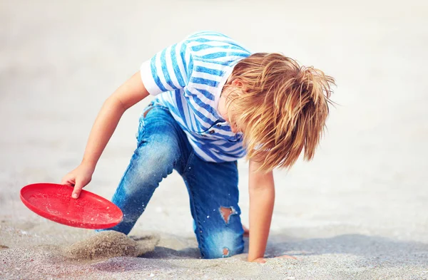 Niño con disco volador en movimiento, jugando juegos de ocio en la playa de arena — Foto de Stock