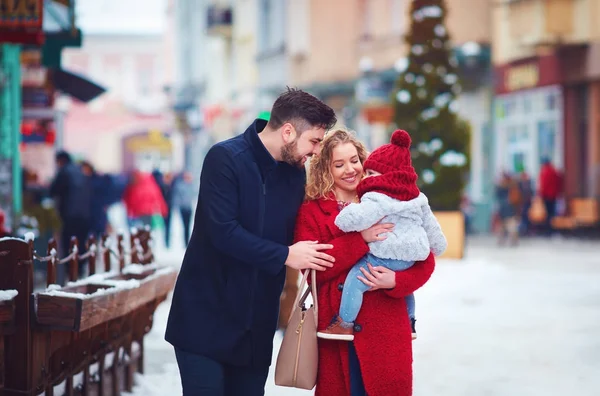 Família feliz, mãe, pai e bebê andando pela rua da cidade nevada de inverno — Fotografia de Stock