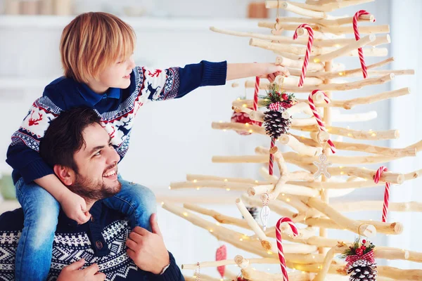 Lycklig familj, far och son dekorera handgjorda julgran gjord av drivved hemma — Stockfoto