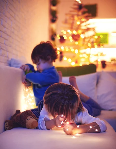 Crianças bonitos, irmãos jogando em casa na véspera de Natal Fotos De Bancos De Imagens