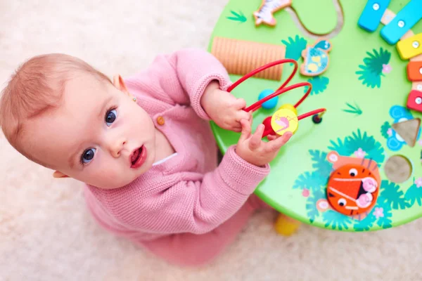 Nieuwsgierig meisje speelt met de ontwikkeling van houten speelgoed — Stockfoto
