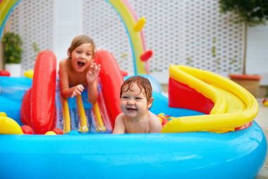 heyecanlı çocuk, renkli şişme havuzu veranda üzerinde eğleniyor aile