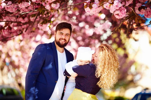 Retrato de familia feliz en el floreciente parque de primavera — Foto de Stock