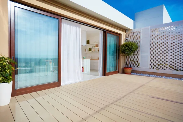 Roof top patio with open space kitchen, sliding doors and decking on upper floor — Stock Photo, Image