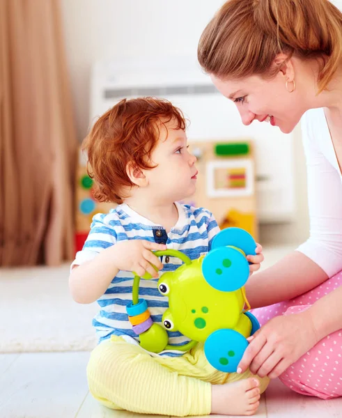 Cheerful young woman, mother playing games with kids at nursery room — Stock Photo, Image