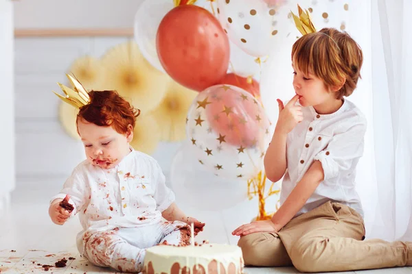 Lindo niños, hermanos degustación de pastel de cumpleaños en la primera fiesta de cumpleaños —  Fotos de Stock