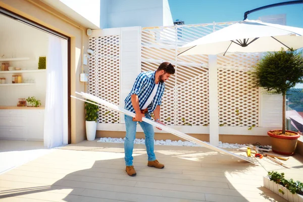 Man renovating rooftop patio zone with open space kitchen — Stock Photo, Image