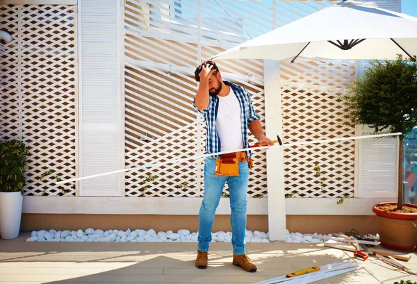 Young adult man building wooden pergola wall on rooftop patio zone — Stock Photo, Image