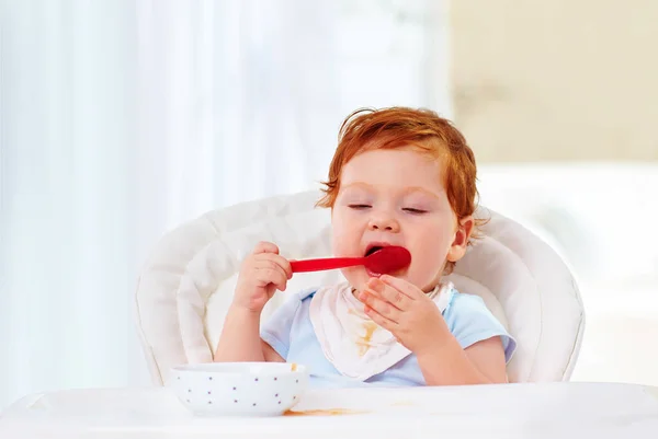 Lindo bebé pequeño niño aprender a sostener la cuchara y comer por sí mismo —  Fotos de Stock