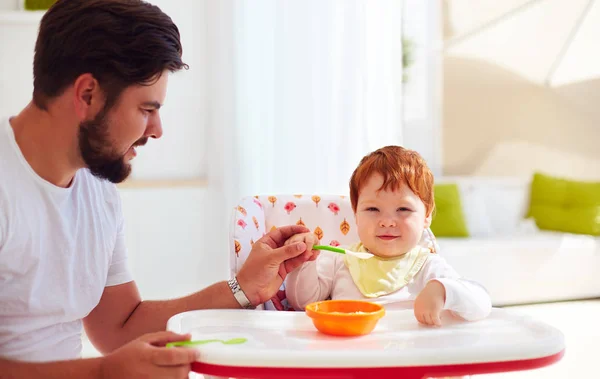 Pai ensina filho, bebê para segurar a colher e comer por conta própria — Fotografia de Stock