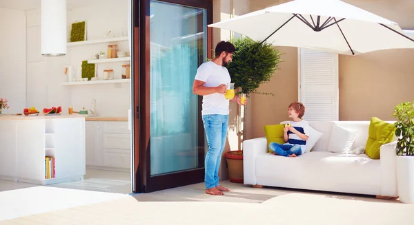 Pai e filho, família relaxante no pátio do último piso com cozinha de espaço aberto no dia quente de verão — Fotografia de Stock