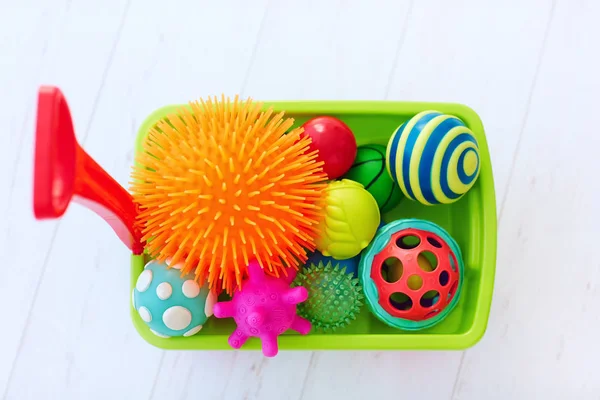 Colorful toy trolley full of vibrant and various shape tactile balls for kid's development — Stock Photo, Image