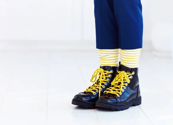 Stylish look of patent leather ankle boots with yellow shoelaces and socks at young boy — Stock Photo, Image