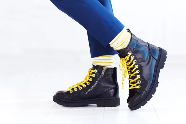 Стильный внешний вид лакированной кожи лодыжки сапоги с желтыми шнурками и носки на мальчика — стоковое фото