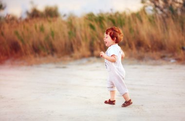 açık havada, yaz alan yürüyüş memnun Kızıl saçlı toddler bebek
