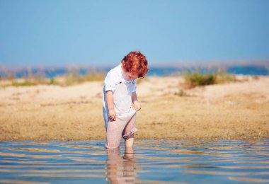 şirin Kızıl saçlı toddler bebek çocuk giyim sabah Gölü sığ suda soaks