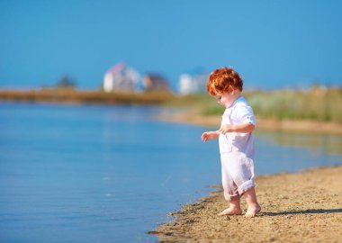 şirin Kızıl saçlı erkek bebek toddler Gölü sahilinde yaz sabahları yürüyüş