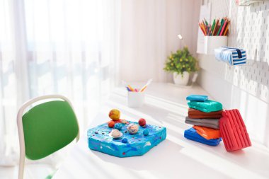 Çocukların plastikinden yapılmış el yapımı güneş sistemi, çocuk odasındaki masanın üstünde, okul projesi.